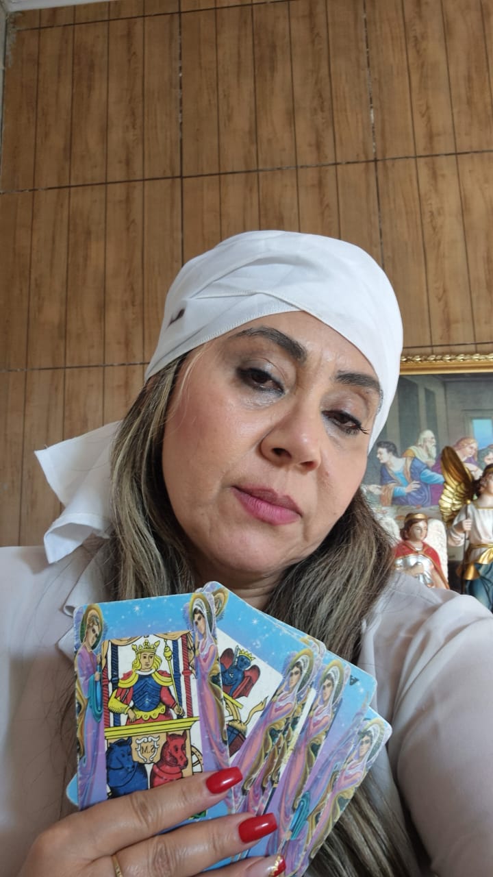 Marina Luz segurando cartas de tarot durante uma consulta